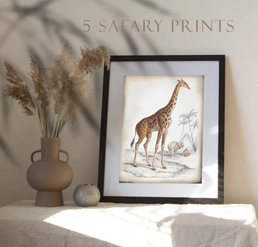 A framed watercolor giraffe head illustration with floral elements on a wooden table.