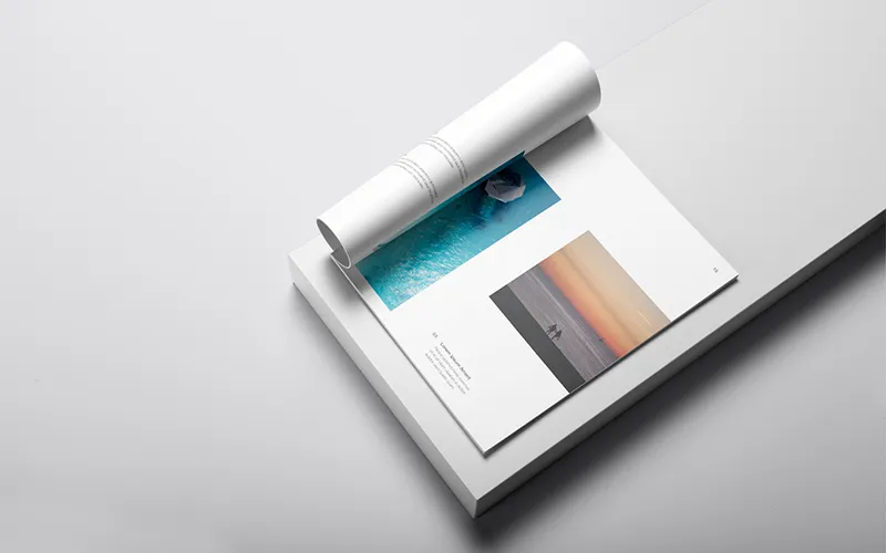 Open booklet with ocean and sunset photography, featuring elegant layout and page numbers